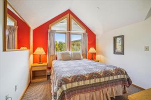 1 dormitorio con 1 cama con paredes de color naranja y ventana en Welcoming Two bedroom Highridge Condo J3, en Killington