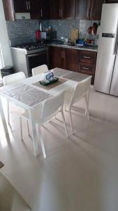 uma cozinha com uma mesa branca e electrodomésticos brancos em Edificio Alendyx em Dajabón