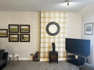 a living room with a tv and a clock on the wall at 1 Bed Flat - Sleeps 2 - Parking - Wifi in Ayr