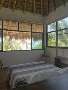 a bedroom with a bed and two windows in a room at Casa shanti penthouse with AC in Puerto Escondido