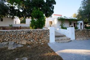 a stone retaining wall with stairs and a stone fence at Can Vich in Sant Carles de Peralta