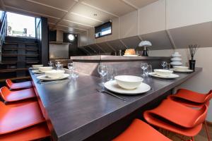 a dining room with a long table with red chairs at LA PENICHE in Colmar