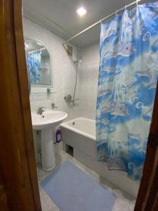 uma casa de banho com um lavatório e uma cortina de chuveiro em Cozy corner right in the center! em Tashkent