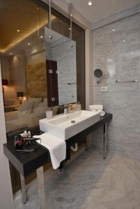 a bathroom with a sink and a living room at Hotel Atina by ENTOPYA in Budva +52 photos