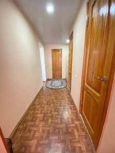 um corredor vazio com uma porta de madeira e um piso de madeira em Cozy corner right in the center! em Tashkent