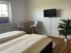 a bedroom with a bed and a flat screen tv at Berghotel Sülbeck in Nienstädt