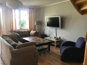 sala de estar con sofá, mesa y TV en Nella en Darłowo