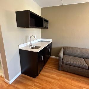 a kitchen with a sink and a couch in a room at Econo Lodge in Danville