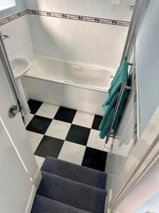 a bathroom with a staircase leading to a bath tub at Manor Inn Galmpton in Brixham