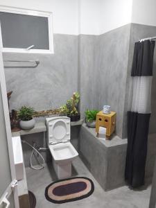 a bathroom with a toilet and a shower with plants at Dhanudi Homestay in Ella