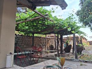 un patio con mesa y sillas bajo una pérgola en Casa por temporada en Goiás