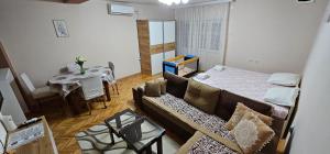 a living room with a couch and a bed and a table at Stavrov Apartment in Negotino