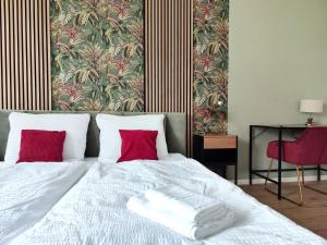 1 dormitorio con cama blanca y almohadas rojas en tealounge 2 Raum + Küche en Dresden