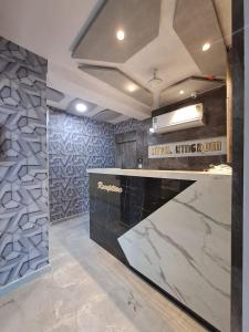 a kitchen with a marble counter and a wall at HOTEL KINGDOM in Gandhinagar