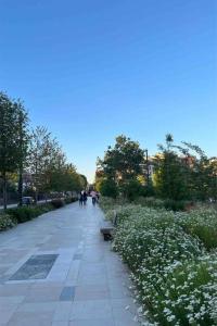una passerella in un parco con panchina e fiori di Nice sunny apartment of 70m2 a Montrouge