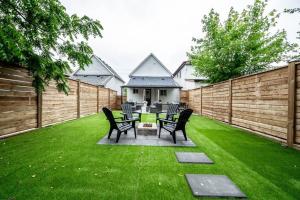 a backyard with a table and chairs on the grass at Luxury Stylish Home, Walk to Falls, Fire Pit&More in Niagara Falls
