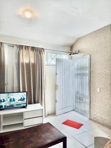 uma sala de estar com uma televisão e uma porta de correr em Próximo shopping Beira Mar em Florianópolis
