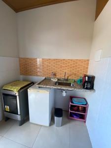 a small kitchen with a sink and a refrigerator at Residencial Aquidabã in Angra dos Reis