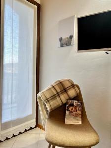 a living room with a chair with a magazine on it at Casa Nina in Andalo