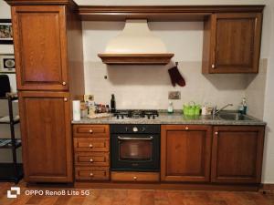 a kitchen with wooden cabinets and a stove top oven at Agriturismo Uliveto Gretacci in Montemerano