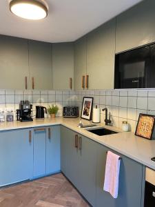 a kitchen with blue cabinets and a sink at Tanya's Place-Stylish flat in Marylebone in London