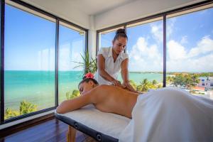 a woman giving a man a massage in a bedroom at The Ellysian Boutique Hotel in Placencia Village