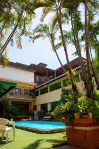 un complejo con piscina y palmeras en Hotel Santo Domingo, en Asunción