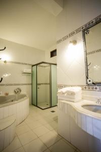 ein Bad mit einer Badewanne, einem Waschbecken und einer Dusche in der Unterkunft Hotel Santo Domingo in Asunción
