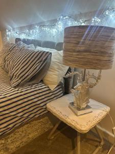 Cozy 1 bed Urban Haven في Swithland: مصباح على طاولة بجوار سرير