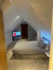 a bedroom with a bed and a flat screen tv at Cozy 1 bed Urban Haven in Swithland