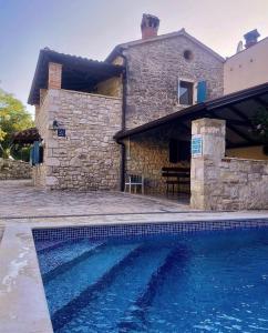 a house with a swimming pool in front of a house at Holiday Houses Luan in Poreč