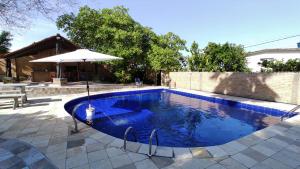 a large swimming pool with an umbrella and an umbrella at Casa inteira, com sauna, piscina ozonizada, praia Enseada dos Corais, Cabo de Santo Agostinho, Pernambuco, Brasil in Cabo de Santo Agostinho