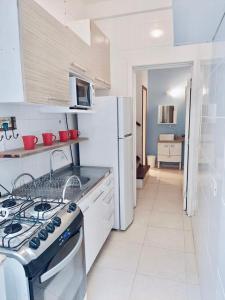 a white kitchen with a stove and a refrigerator at Próximo shopping Beira Mar in Florianópolis