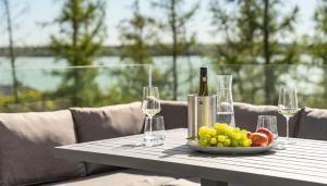 einen Tisch mit einem Obstteller und einer Flasche Wein in der Unterkunft KANANI am Hainer See in Neukieritzsch