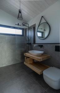 ein Bad mit einem Waschbecken und einem Spiegel in der Unterkunft KANANI am Hainer See in Neukieritzsch
