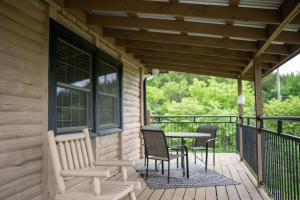 eine Terrasse mit Stühlen und einem Tisch auf der Veranda in der Unterkunft Lands End - 267 Ridge Lane in Branson