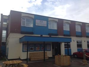 a building with a blue awning and a table outside at Pelham Hotel in Immingham