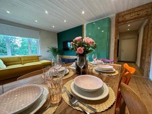 a dining room with a table with plates and flowers on it at Magical two bedroom apartment in Viljandi in Viljandi