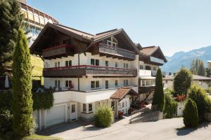 ein großes weißes Gebäude mit Bäumen davor in der Unterkunft Appartement Désirée inkl der SUPER SOMMER CARD im SOMMER 2025 in Serfaus