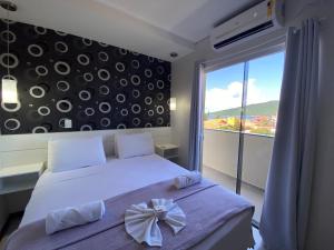 a bedroom with a bed with a bow on it at Parada Beach Beira-Mar e Aptos 70m do Mar in Florianópolis
