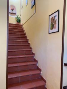 un conjunto de escaleras en una casa con baldosas rojas en Notti Etrusche a Sovana, en Sovana