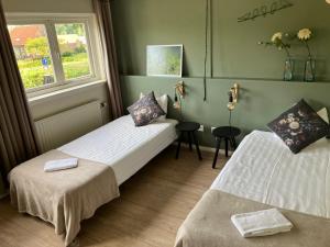 two beds in a room with a window at Hotel Restaurant In d'Ouwe Peel in Helenaveen +103 photos