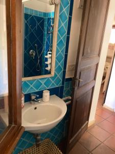 ein Bad mit einem Waschbecken und einem Spiegel in der Unterkunft Villasimius villetta a 300 mt dalla spiaggia in Villasimius