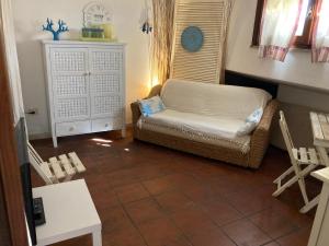 uma sala de estar com um sofá, uma mesa e cadeiras em Villasimius villetta a 300 mt dalla spiaggia em Villasimius