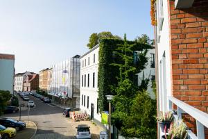 una calle de la ciudad con un edificio blanco con una pared verde en Gemütliche Ferienwohnung in der Altstadt en Schwerin