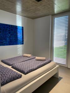 Bett in einem Schlafzimmer mit Wandgemälde in der Unterkunft VOO residence in Malečnik