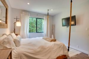 een slaapkamer met een groot wit bed in een kamer met een raam bij Malibu Retreat with Balcony and Mountain Views in Malibu