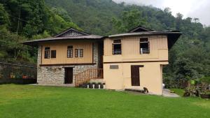 a house in a field with a grass yard at Phamlhakhang Ecohomestay in Pelling