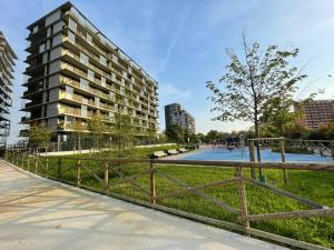 un parque con una valla de madera y un edificio en Stupendo appartamento in Fiera Milano-Up Town, en Pero