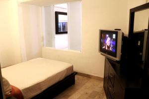 a bedroom with a bed and a tv and a window at Luxurious Apartment, Oceanfront, spectacular view in Acapulco